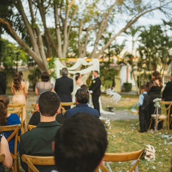 Une cérémonie laïque en plein air : les invités assis face à une arche fleurie